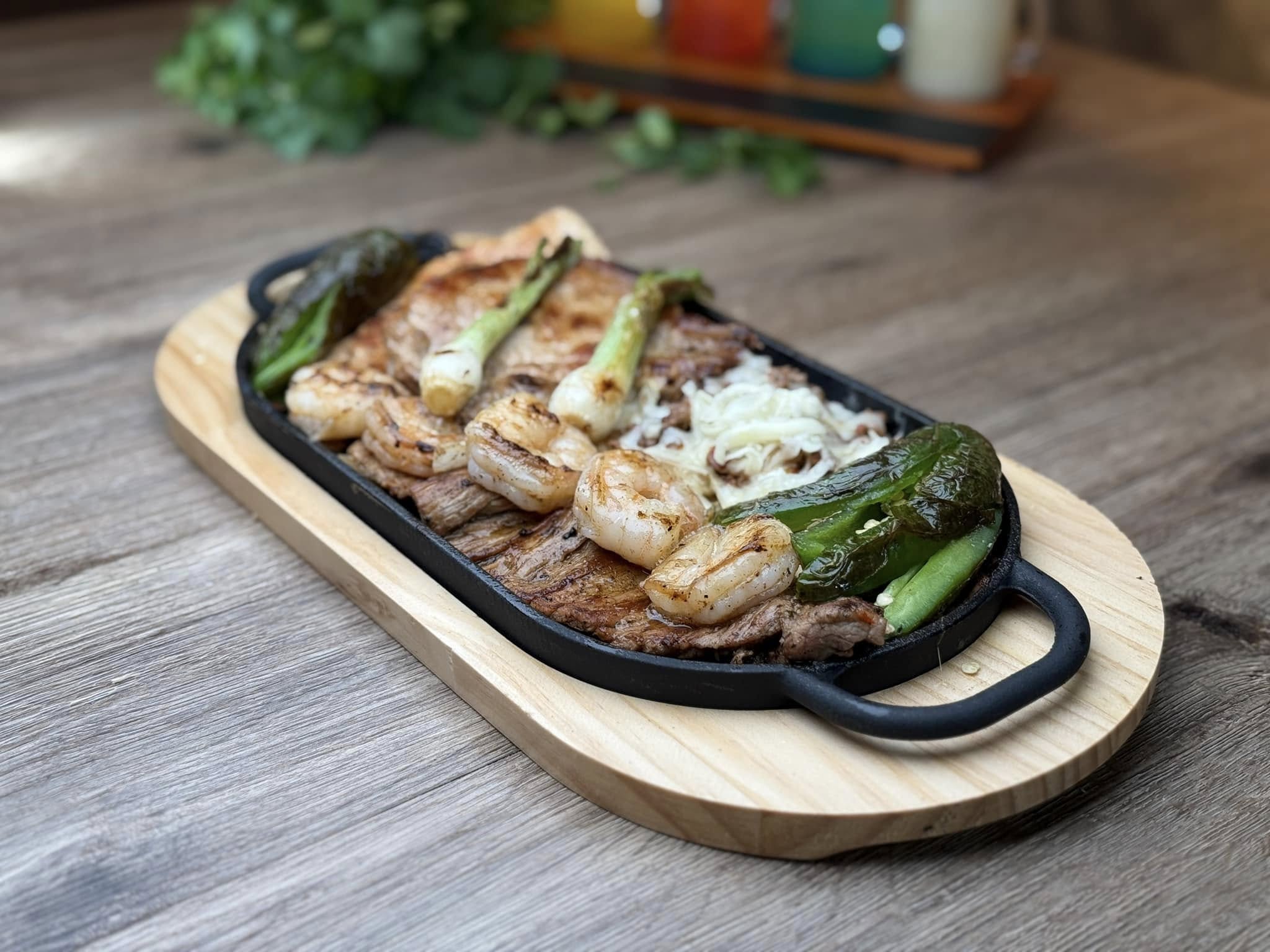 Plated Mexican dish from El Salto featuring shrimp, steak, and grilled jalapeños.