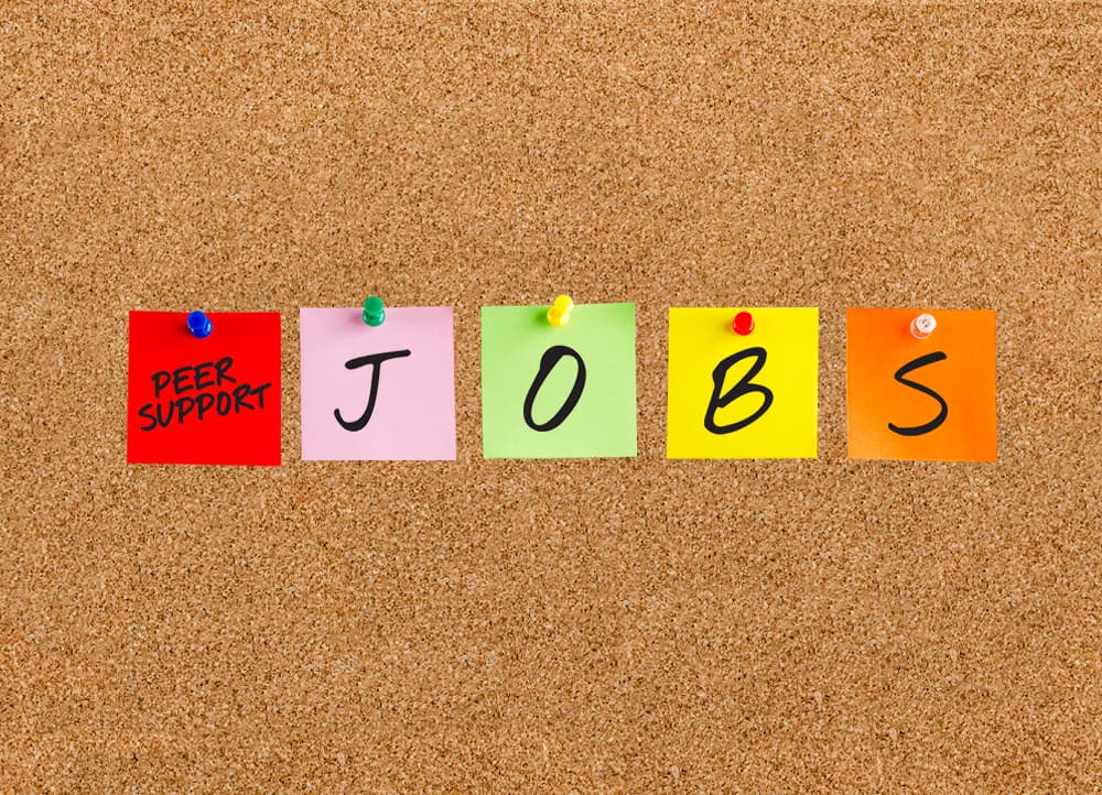 A diverse group of people put their hands together to form a circle